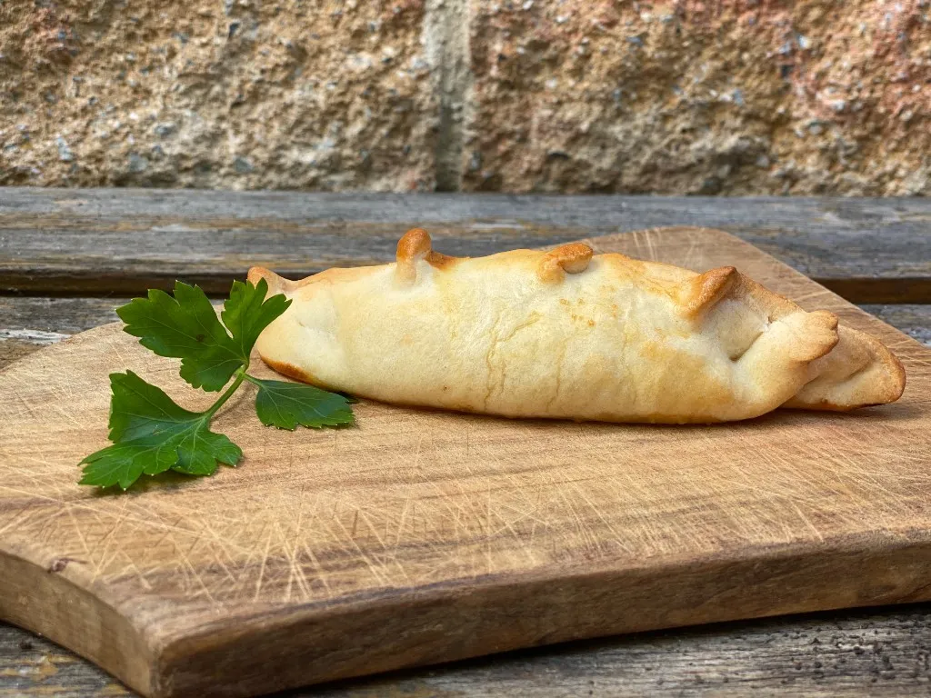 Hähnchen-Empanada, goldbraun gebacken mit charakteristischen Repulgue-Spitzen