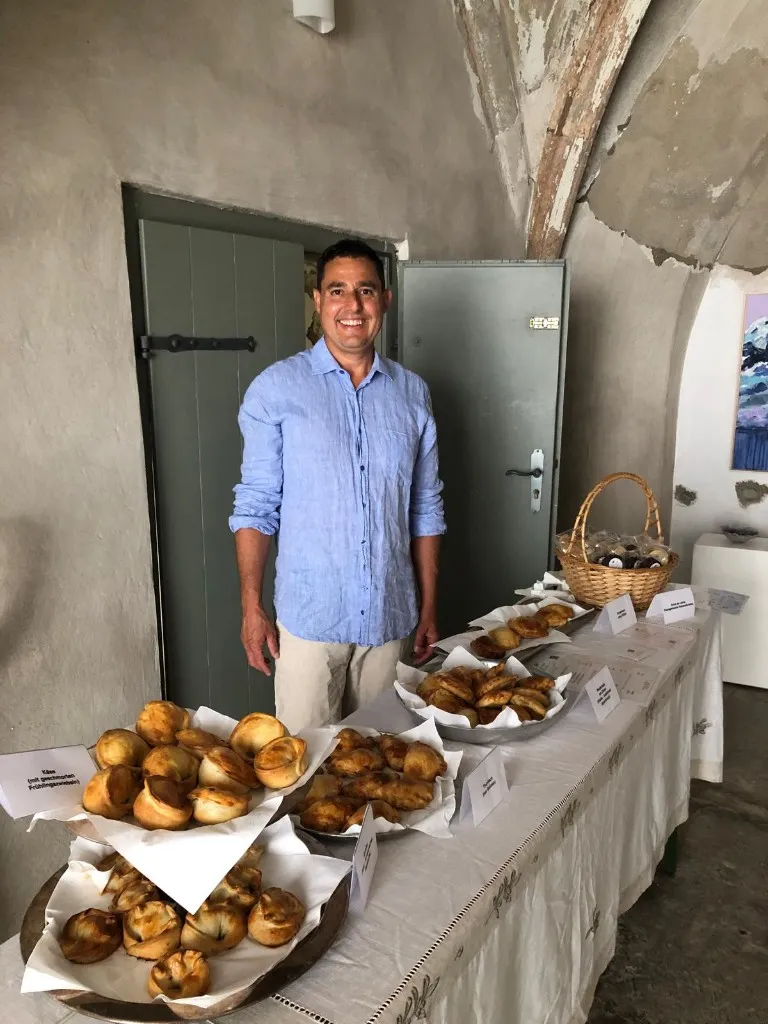 Diego hinter dem Buffet mit Empanadas und Alfajores bei der Passauer Kunstnacht.